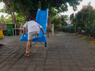 Küçük Asyalı bir kızın oyun parkındaki aktiviteler 