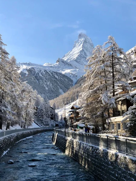 瑞士泽尔马特阳光灿烂的天气 积雪覆盖着树木和高山 包括马特宏河 还有穿过小镇的河流 — 图库照片