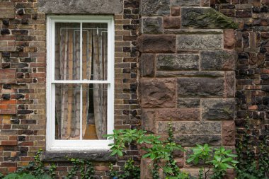 Kahverengi bloklar duvarındaki beyaz pencereye bak