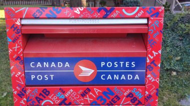 Toronto, ON, Kanada - 5 Ekim 2025: Kanada Posta Kutusunun kırmızı ve mavi tasarımı ve iki dilli Kanada Posta logosu