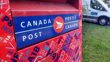Toronto, ON, Kanada - 5 Ekim 2025: Kanada Posta Kutusunun kırmızı ve mavi tasarımı ve iki dilli Kanada Posta logosu