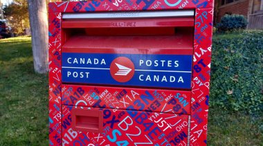 Toronto, ON, Kanada - 5 Ekim 2025: Kanada Posta Kutusunun kırmızı ve mavi tasarımı ve iki dilli Kanada Posta logosu
