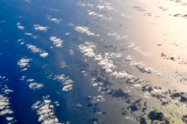 Uçsuz bucaksız mavi gökyüzü muazzam kümülüs bulutlarını ve parlak güneş ışığını sarar..