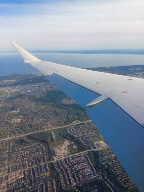 Mississauga, ON, Canada, September 26, 2024: Aerial view of suburban neighbourhoods and Lake Ontario as a plane approaches Toronto Pearson International Airport..