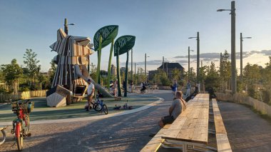 Toronto, ON, Kanada - 13 Ekim 2025: Toronto 'daki Biidaasige Park' ta ahşap yapıları olan bir şehir parkı ve insanlar renkli bir günbatımının keyfini çıkarıyorlar..