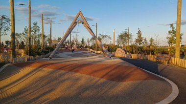 Toronto, ON, Kanada - 13 Ekim 2025: Toronto 'daki Biidaasige Park' ta ahşap yapıları olan bir şehir parkı ve insanlar renkli bir günbatımının keyfini çıkarıyorlar..
