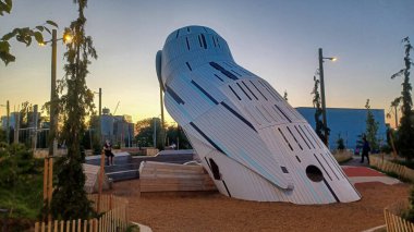 Toronto, ON, Kanada - 13 Ekim 2025: Toronto 'daki Biidaasige Park' ta ahşap yapıları olan bir şehir parkı ve insanlar renkli bir günbatımının keyfini çıkarıyorlar..