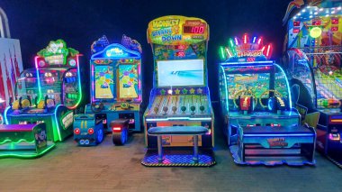 Toronto, ON, Kanada - 7 Ekim 2025: Çeşitli renkli atari makineleri eğlence merkezinde arka arkaya dururlar.