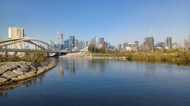 Toronto, ON, Kanada - 13 Ekim 2025: Şehir merkezi gökyüzü modern bir yaya köprüsünün yanındaki su üzerinde görülebiliyor.