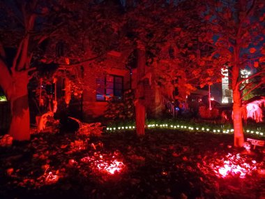 Toronto, ON, Kanada 31 Ekim 2024: Çimlerde ve balkonda parlayan Cadılar Bayramı şişme bebekleri, hayaletler, balkabakları ve ürkütücü bir ağaç...