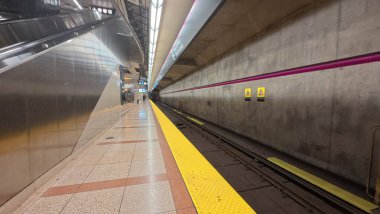 Toronto, ON, Kanada - 18 Ekim 2025: Boş bir metro platformu işaretli ve raylı modern bir istasyon gösteriyor.