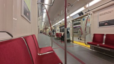 Toronto, ON, Kanada - 18 Ekim 2025: Kırmızı koltuklu bir toplu taşıma metrosunun içi çoğunlukla boş.