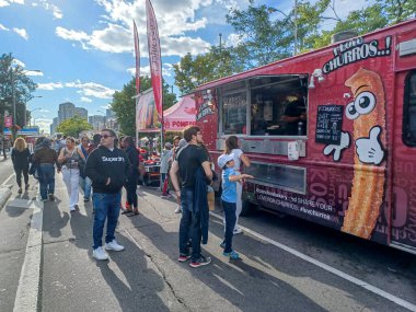 Toronto, ON, Kanada 9 Eylül 2024: İnsanlar güneşli bir öğleden sonra yemek standı, müzik ve etkinlikleriyle Kingsway Street Festivali 'nin tadını çıkarıyor..