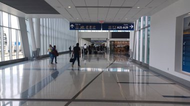 Charlotte, NC, ABD, 10 Ekim 2025: Bagajlı insanlar Charlotte Douglas Uluslararası Havalimanı 'nda parlak ve ferah bir salonda yürüyorlar