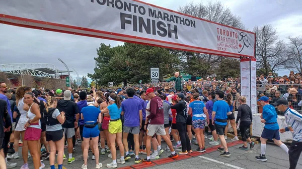 Toronto, ON, Kanada - 29 Nisan 2025: Toronto Maratonu bitiş çizgisinde büyük bir koşucu grubu toplanıyor. Çok sayıda koşucu ve dar yol geçişi imkansız kılıyor..