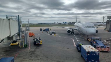 Charlotte, NC, ABD - 10 Ekim 2025: Bir Amerikan Havayolları uçağına yer ekibi ve destek araçları havaalanı kapısında hizmet vermektedir..