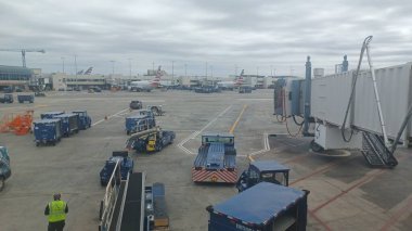 Charlotte, NC, ABD - 10 Ekim 2025: Bir Amerikan Havayolları uçağına yer ekibi ve destek araçları havaalanı kapısında hizmet vermektedir..