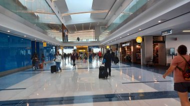 Charlotte, NC, ABD, 10 Ekim 2025: Bagajlı insanlar Charlotte Douglas Uluslararası Havalimanı 'nda parlak ve ferah bir salonda yürüyorlar