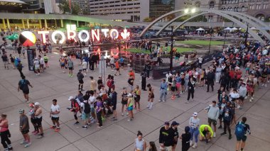Toronto, Kanada - 19 Ekim 2025: Toronto Waterfront maratonu sırasında koşucular ve izleyicilerle birlikte Nathan Phillips Meydanı 'nın sabah manzarası. 