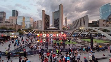 Toronto, Kanada - 19 Ekim 2025: Toronto Waterfront maratonu sırasında koşucular ve izleyicilerle birlikte Nathan Phillips Meydanı 'nın sabah manzarası. 