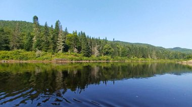 Quebec 'teki Jacques Cartier gölüne bakın. Berrak sularda yansıyor, yaz doğasını ve vahşi doğayı gösteriyor..