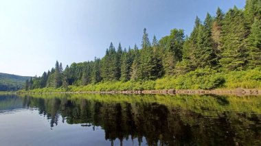 Quebec 'teki Jacques Cartier gölüne bakın. Berrak sularda yansıyor, yaz doğasını ve vahşi doğayı gösteriyor..