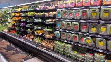 Montreal, QC, Kanada - 1 Ağustos 2025: Çeşitli gıda ürünleriyle dolu raflarla dolu bir markette geniş ve parlak bir koridor aşağı doğru bir manzara.