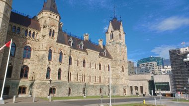 Ottawa, ON, Kanada - 31 Ekim 2025 etkileyici, tarihi Parliament Hill binası Viktorya Dönemi Gotik mimarisi ve taş cephesini parlak mavi gökyüzü altında sergiliyor.