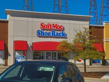 Toronto, ON, Kanada - 19 Eylül 2025: Güneşli bir günde kırmızı tenteli ve binanın önünde park yeri olan SoftMoc Shoe Rack mağazası.