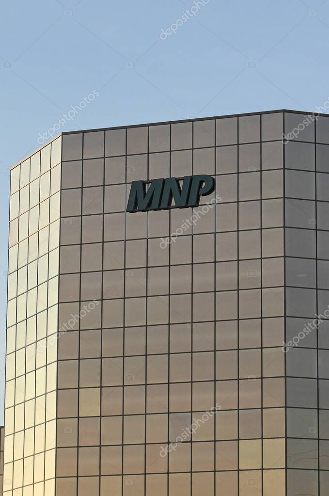 Calgary, AB, Canada - September 18, 2025: A sleek glass tower displays the MNP logo and Canadian flag against a clear blue sky.