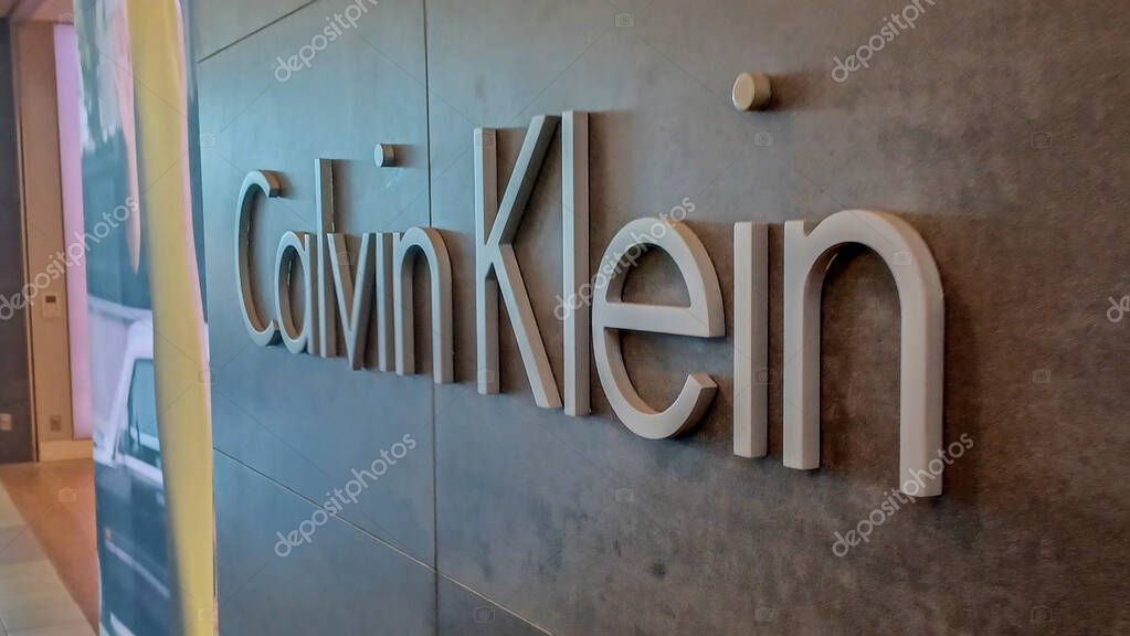 Toronto, ON, Canada - August 30, 2025: The Calvin Klein logo is mounted on a gray tile wall inside a retail store.