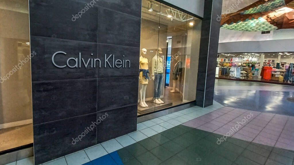 Toronto, ON, Canada - August 30, 2025: The Calvin Klein logo is mounted on a gray tile wall inside a retail store.