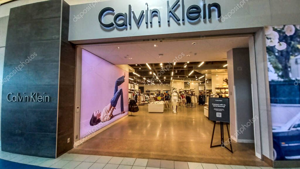 Toronto, ON, Canada - August 30, 2025: The Calvin Klein logo is mounted on a gray tile wall inside a retail store.