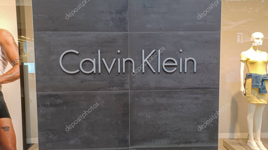 Toronto, ON, Canada - August 30, 2025: The Calvin Klein logo is mounted on a gray tile wall inside a retail store.