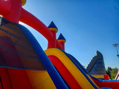 Toronto, ON, Kanada 31 Mayıs 2024: Aileler güneşli bir öğleden sonra bir çocuk etkinliğinde büyük şişme slaytlar ve engelli parkurların etrafında toplandılar..