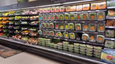 Montreal, QC, Kanada - 1 Ağustos 2025: Çeşitli gıda ürünleriyle dolu raflarla dolu bir markette geniş ve parlak bir koridor aşağı doğru bir manzara.