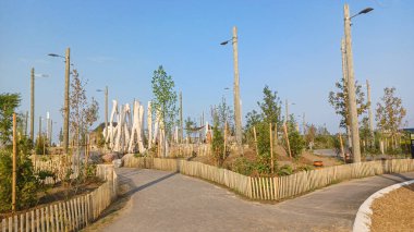 Toronto, ON, Kanada - 13 Ekim 2025: Toronto 'daki Biidaasige Park' ta ahşap yapıları olan bir şehir parkı ve insanlar renkli bir günbatımının keyfini çıkarıyorlar..