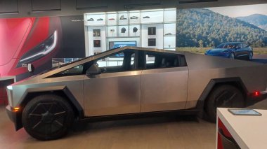 Toronto, ON, Kanada - 8 Kasım 2025: Kırmızı bir Tesla Model Y ve beyaz bir Tesla aracı büyük camlı ve kırmızı duvar aksanlı modern bir Tesla galerisinde sergilenmektedir.