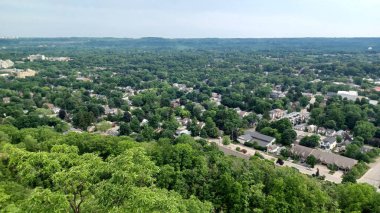 Hamilton, ON, Kanada - 6 Ekim 2025: Yüksek bir manzara, yerleşim alanları, ticari binalar ve çevreye hakim yemyeşil ağaçlarla dolu bir şehir manzarasını gösteriyor.