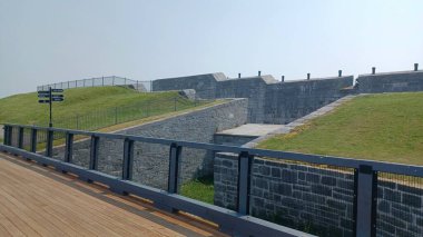 Kingston, ON, Kanada - 5 Ağustos 2025: Büyük, kalın taş duvarlar ve Ontario 'daki tarihi Fort Henry Ulusal Tarihi Bölgesi' nin kenarında savunma topu hattı.