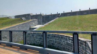 Kingston, ON, Kanada - 5 Ağustos 2025: Büyük, kalın taş duvarlar ve Ontario 'daki tarihi Fort Henry Ulusal Tarihi Bölgesi' nin kenarında savunma topu hattı.