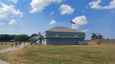 Niagara Gölü üzerinde, ON, Kanada - 15 Eylül 2025: Üzerinde bir Union Jack bayrağı bulunan tarihi mavi kayalık, parlak, bulutlu bir gökyüzünün altındaki çimenli kale sahasında duruyor.