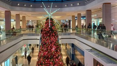 Toronto, ON, Kanada - 19 Kasım 2025: Büyük, parlak ışıklandırılmış bir Noel ağacı, festival tatil sezonunda kapalı bir alışveriş merkezinin en önemli parçası olarak duruyor.