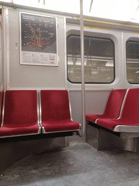 Toronto, ON, Kanada - 6 Eylül 2025: Modern bir metro vagonunun içi kırmızı koltuklar ve istasyonlar arasında seyahat eden birkaç yolcu gösteriyor.