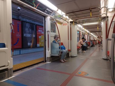 Toronto, ON, Kanada - 6 Eylül 2025: Modern bir metro vagonunun içi kırmızı koltuklar ve istasyonlar arasında seyahat eden birkaç yolcu gösteriyor.