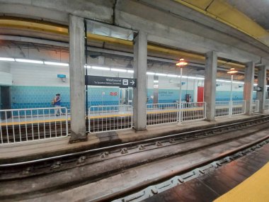 Toronto, ON, Kanada - 8 Eylül 2025: Yeraltı metro istasyonu platformunda kentteki raylar, beton sütunlar ve fayanslı duvarlar yer alıyor.