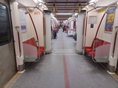 Toronto, ON, Kanada - 6 Eylül 2025: Modern bir metro vagonunun içi kırmızı koltuklar ve istasyonlar arasında seyahat eden birkaç yolcu gösteriyor.