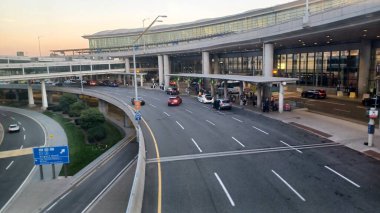 Toronto, Kanada - 15 Ekim 2025: Günbatımında Toronto Pearson Uluslararası bir havaalanı binasının dışında cam mimarisi ve yol seviyeleri görülebilen arabalar ve yolcular görülüyor