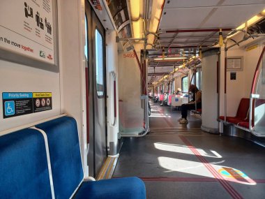 Toronto, ON, Kanada - 6 Eylül 2025: Modern bir metro vagonunun içi kırmızı koltuklar ve istasyonlar arasında seyahat eden birkaç yolcu gösteriyor.