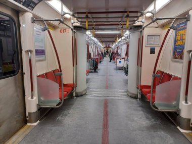 Toronto, ON, Kanada - 6 Eylül 2025: Modern bir metro vagonunun içi kırmızı koltuklar ve istasyonlar arasında seyahat eden birkaç yolcu gösteriyor.